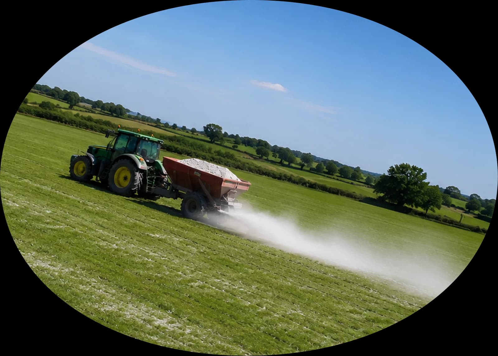 Traktor bringt zerkleinerten Basalt auf Ackerland aus